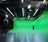 Professional film studio set with a green screen and The Light House production crew members working on the set.