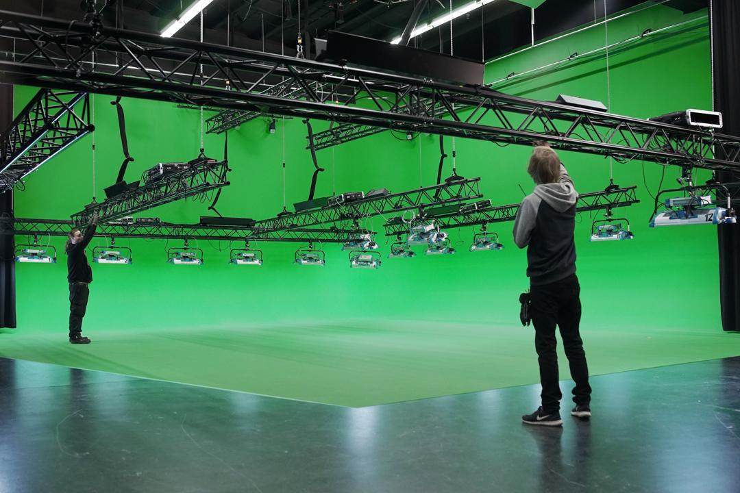 Film studio set with a green screen. The Light House production crew members working on the set.